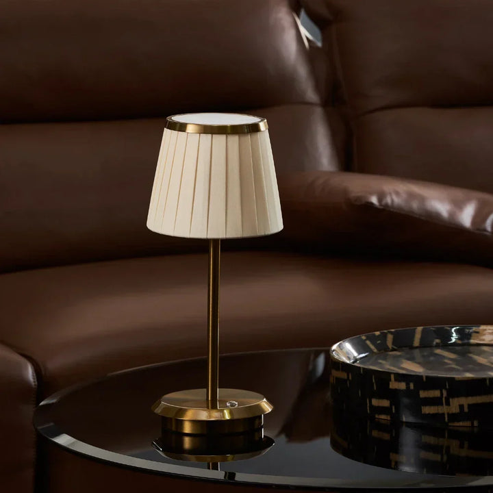 Classic Elegance gold brass table lamp. Refined fabric shade, dimmable LED. Portable modern lighting for any elegant space.