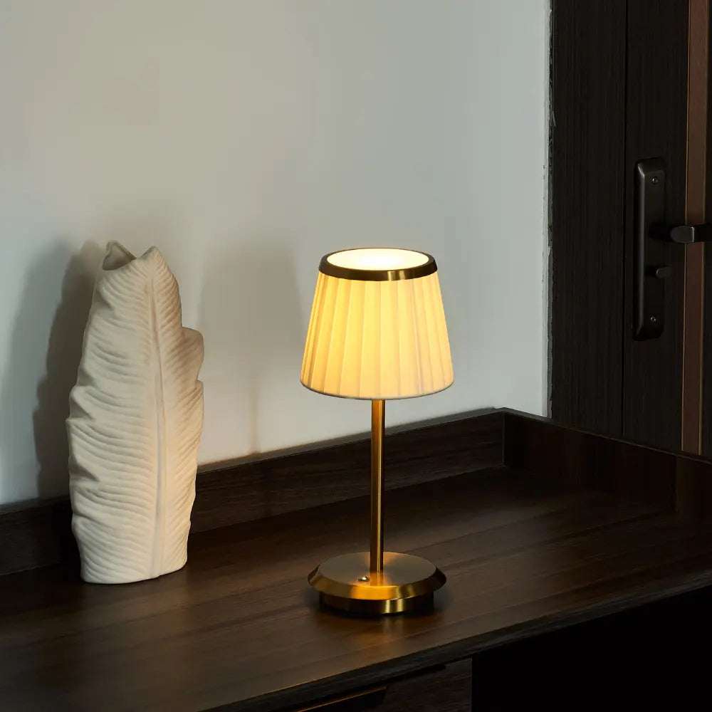Portable Classic Elegance table lamp. Rechargeable LED with fabric shade, gold brass base. Dimmable touch control, indoor/outdoor.