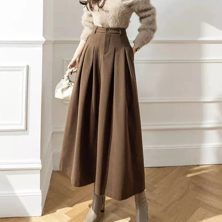 Cozy brown high-waist A-line midi skirt with flowing pleats, stylish for women.