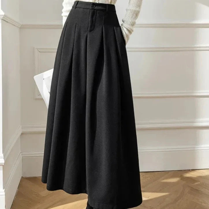Elegant women's black high-waist pleated A-line midi skirt, flowy and comfortable.