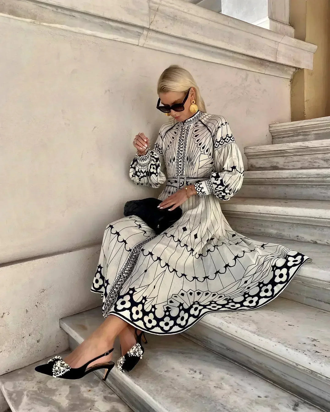 Full-length view of a woman wearing an elegant retro print A-line midi dress, suitable for race day or parties.