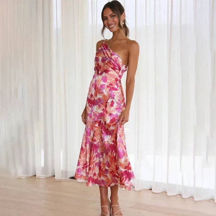 Close-up of elegant women's pink floral print midi dress fabric, showcasing delicate asymmetrical design.