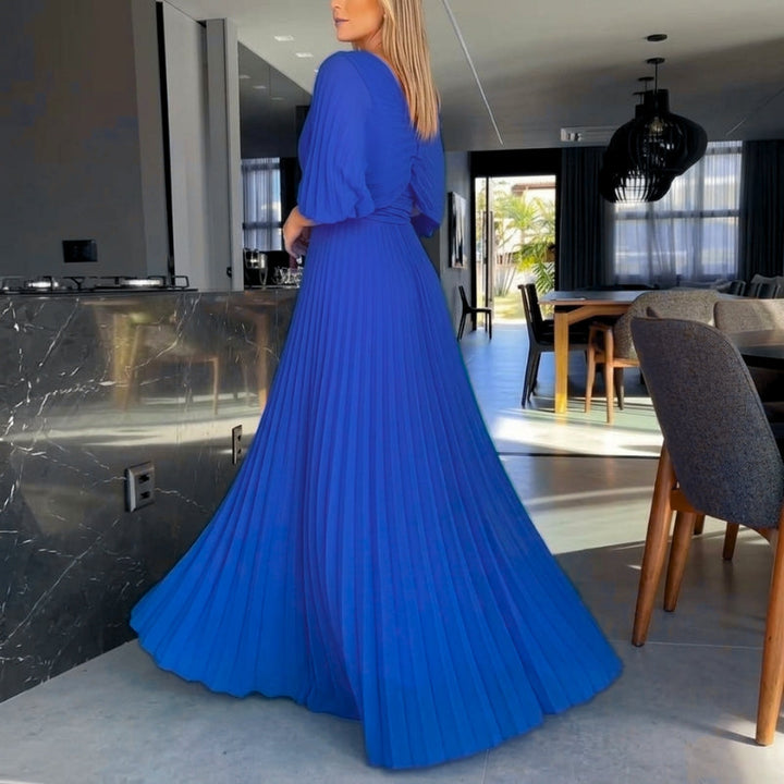 Women's long black dress with a sophisticated pleated design and contemporary cape sleeves.