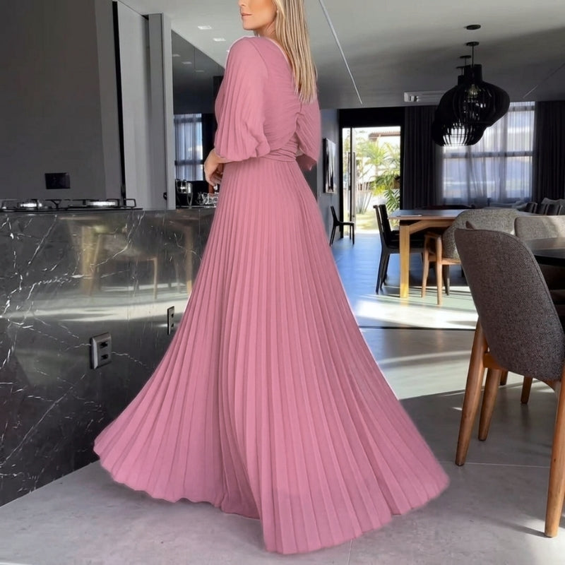 Designer black evening dress with intricate pleats and flowing cape sleeves for a refined look.