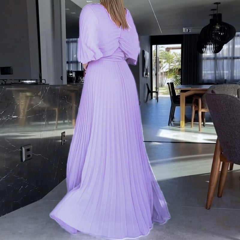 Chic black maxi dress with pleated detailing and dramatic cape sleeves, perfect for parties.