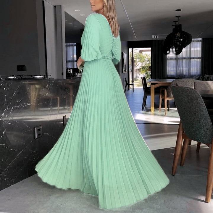 A stunning black evening dress designed with pleated fabric and flowing cape sleeves.