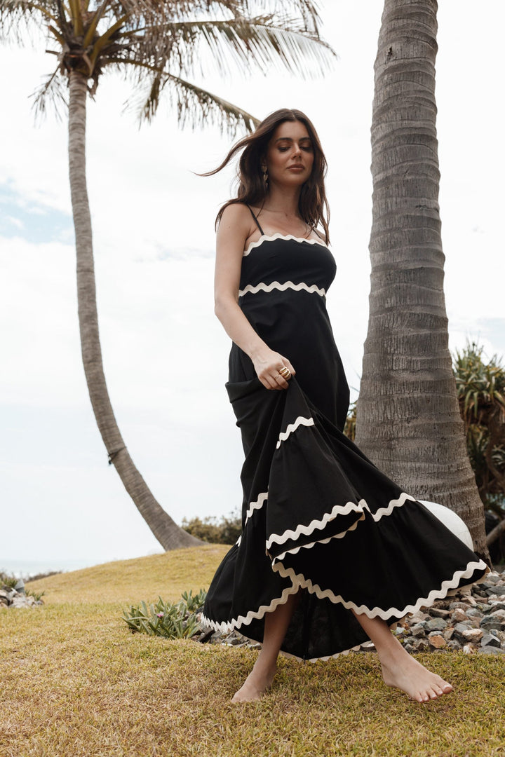 Flowy black women's maxi dress with spaghetti straps, a versatile choice for elegant or casual wear.