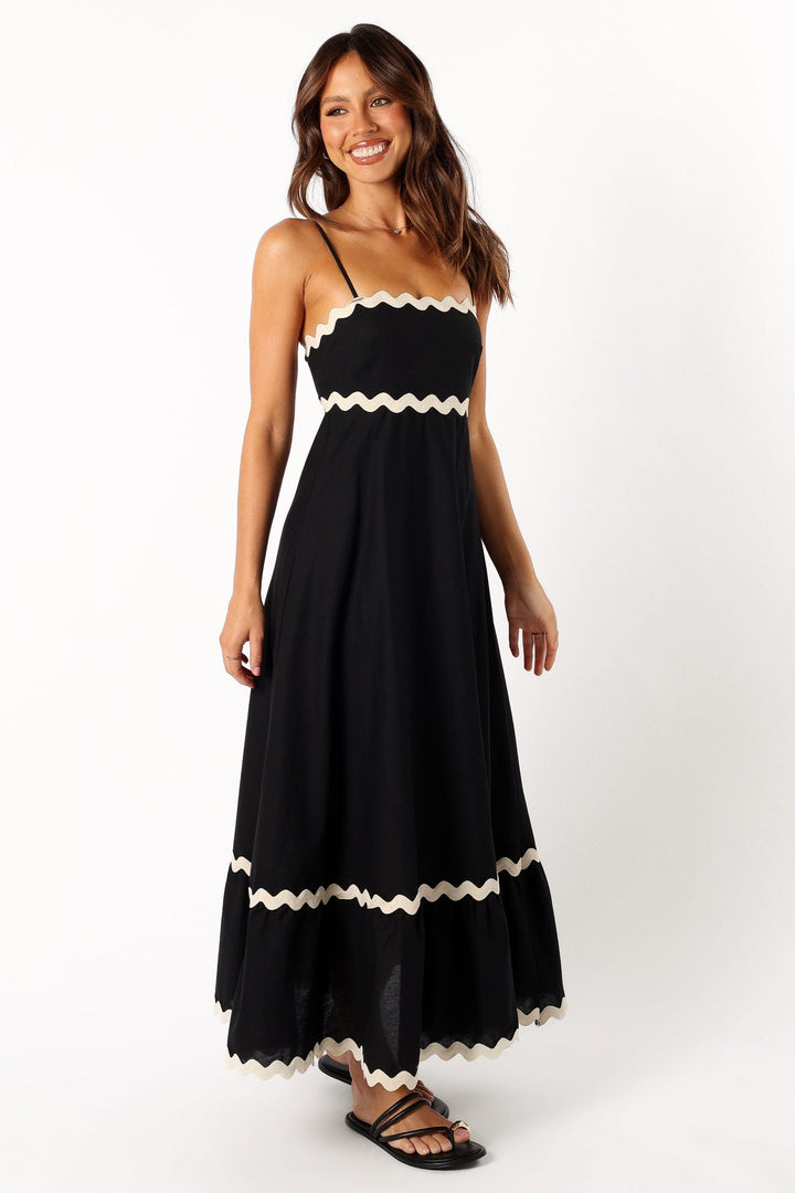 Woman modeling a graceful black strappy maxi dress, suitable for evening, casual, or vacation wear.