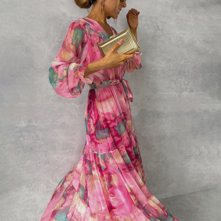 Feminine pink floral wrap maxi dress featuring elegant long sleeves. Comfortable & stylish for any special occasion.