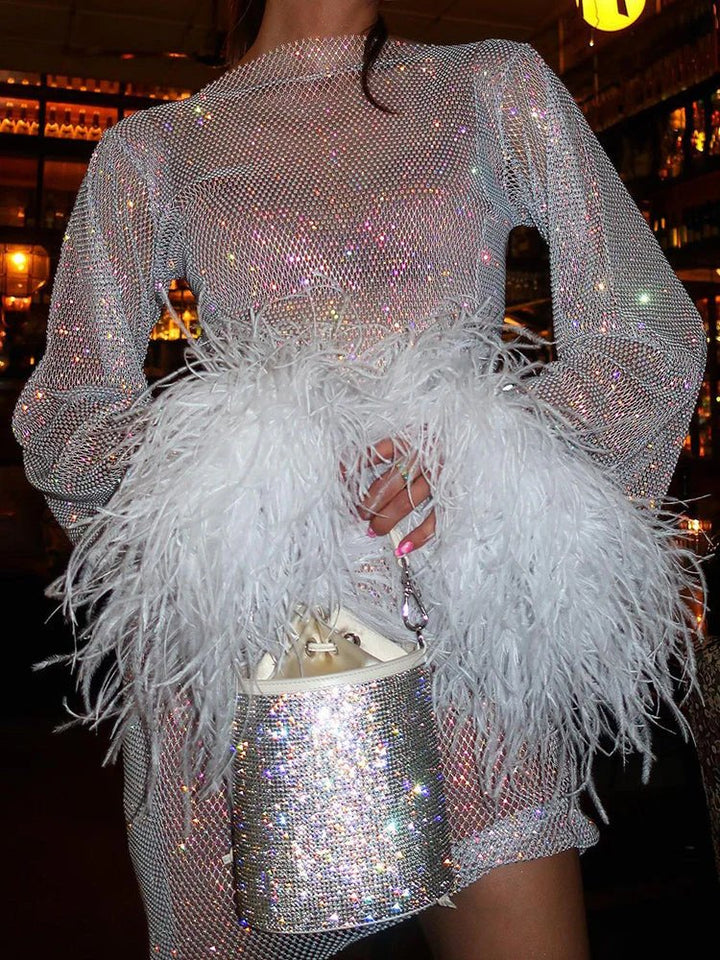 Glamorous party dress: mini silhouette with luxurious feather detailing on cuffs.