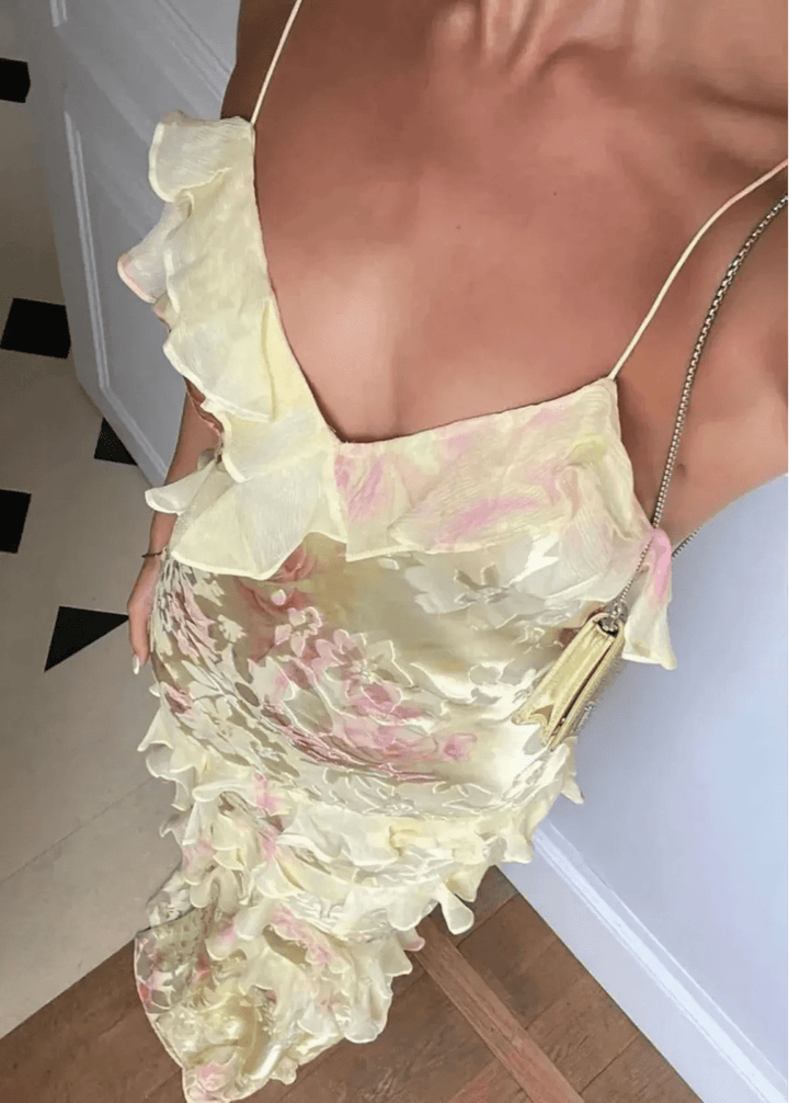 Vibrant yellow floral maxi dress with ruffled hem, a stylish choice for summer gatherings.