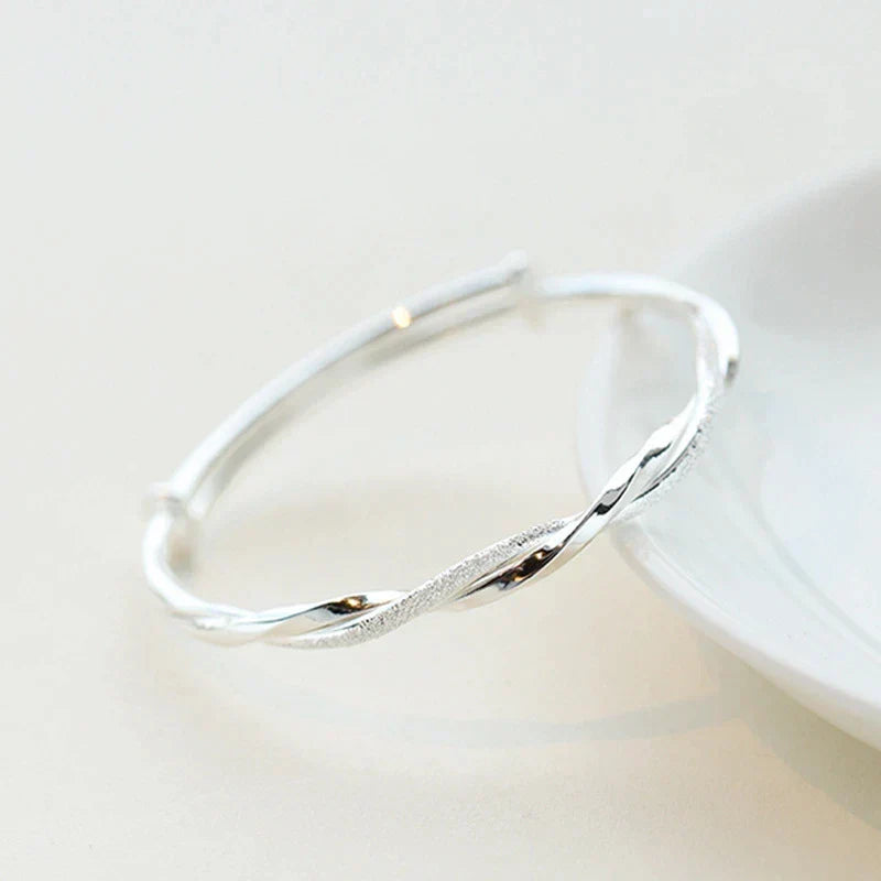 Close-up of an intricate sterling silver bracelet, highlighting its delicate design. Adjustable women's elegant jewelry.