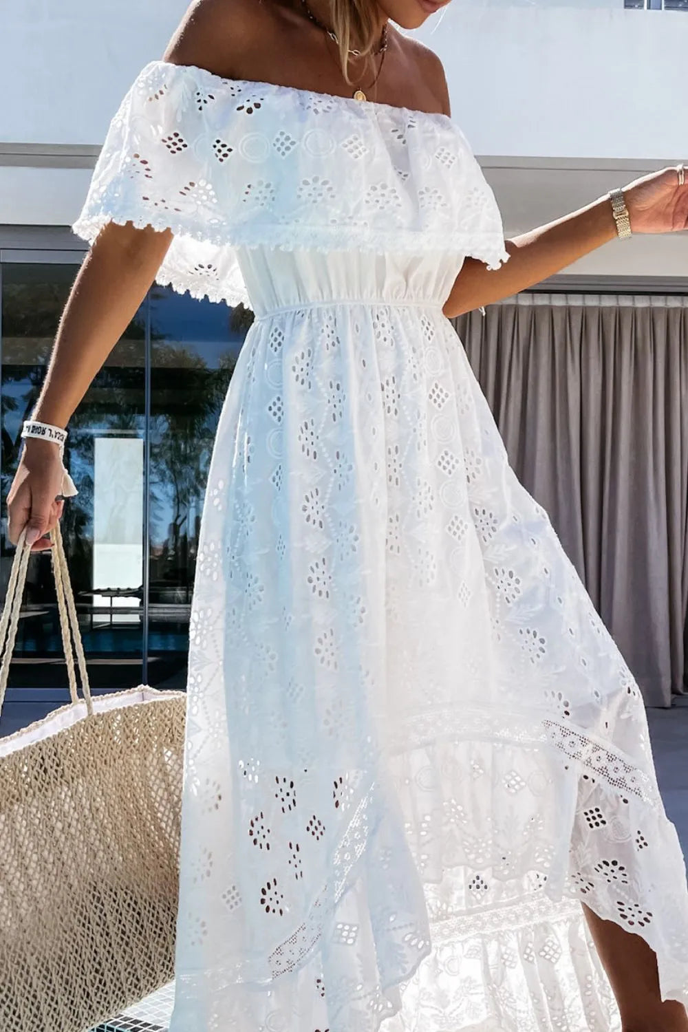 Off-shoulder white lace dress with flowing high-low skirt for summer.