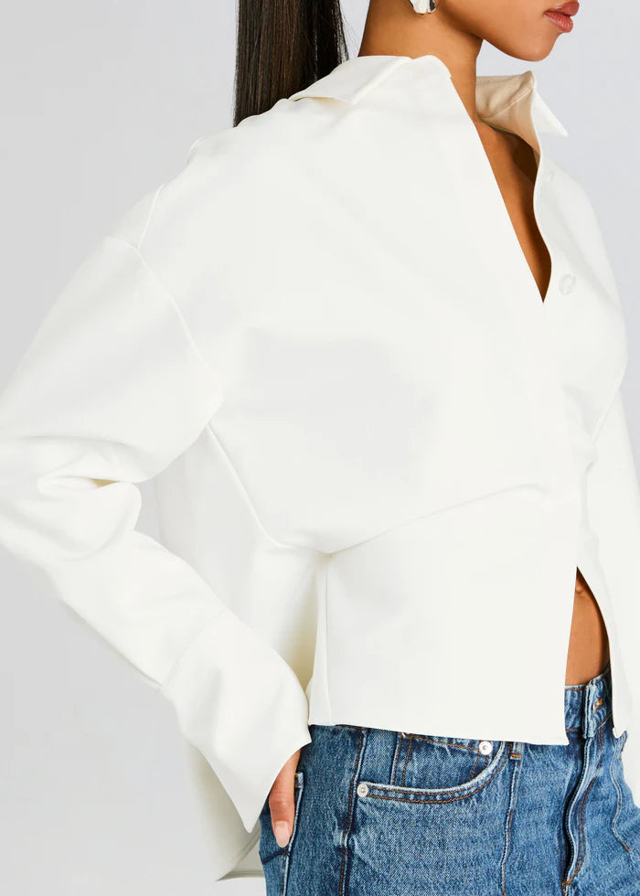 Chic women's white draped button-down shirt with long sleeves, offering a sophisticated and modern silhouette.