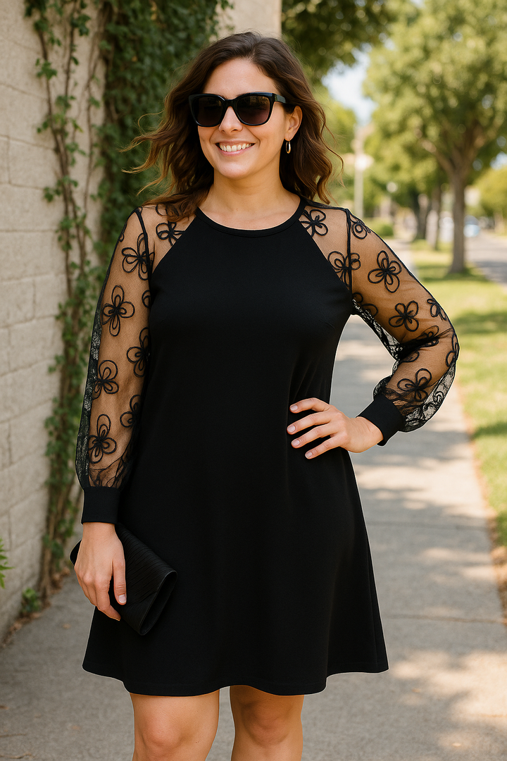 Close-up of the sheer embroidered sleeves on a women's formal A-line midi dress, elegant party wear.