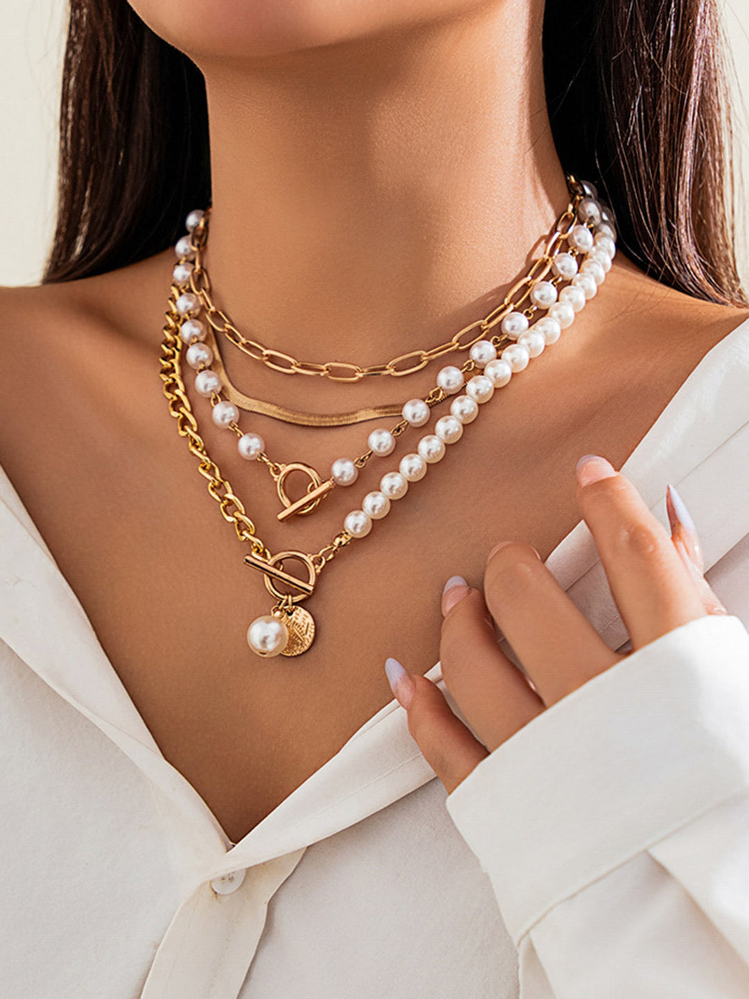 Stylish women's layered gold necklace featuring lustrous pearls. A chic statement jewelry piece for any occasion.