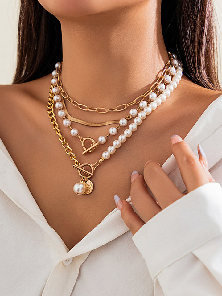 Stylish women's layered gold necklace featuring lustrous pearls. A chic statement jewelry piece for any occasion.