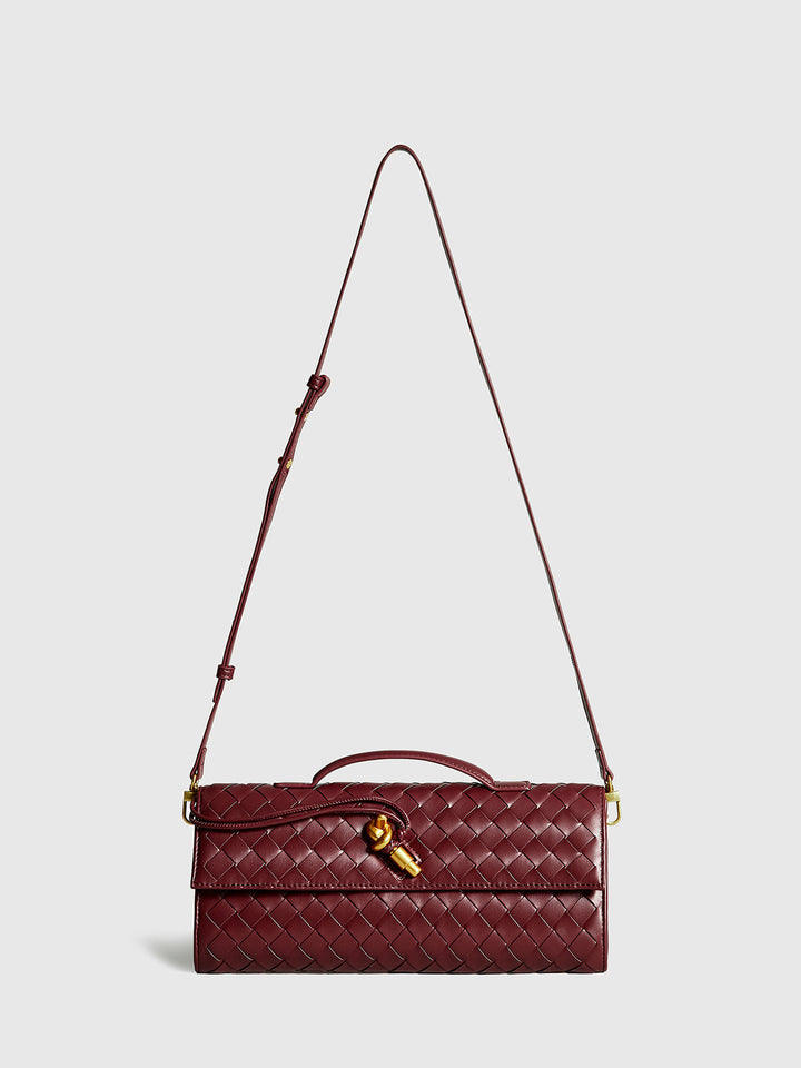 Close-up of intricate woven flap clutch handbag, ideal for women's evening wear.