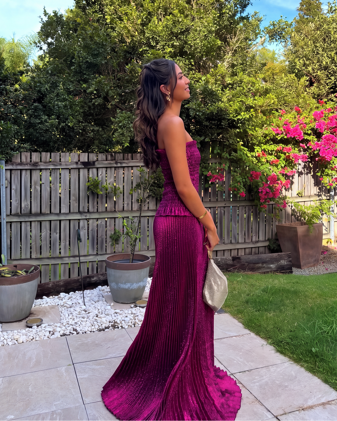 Back view of a women's berry strapless sequin maxi dress, featuring a flowing pleated skirt for gala events.