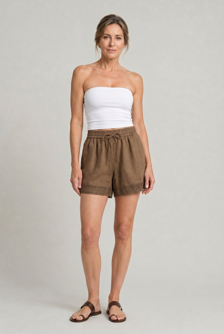 Close-up of delicate crochet trim on women's breathable linen drawstring shorts. Highlights intricate summer detail.