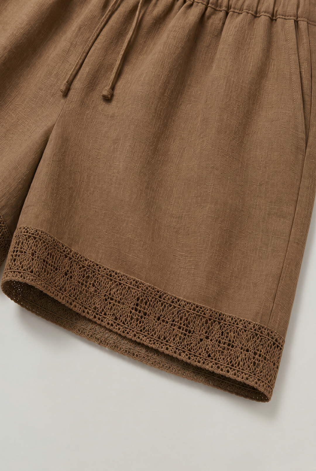 Versatile women's drawstring linen shorts with beautiful crochet trim, great for casual summer outings and comfort.
