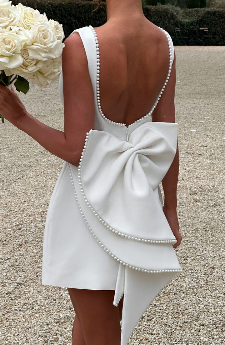 This elegant A-line sleeveless mini dress for women features delicate pearl trim. Perfect for parties.