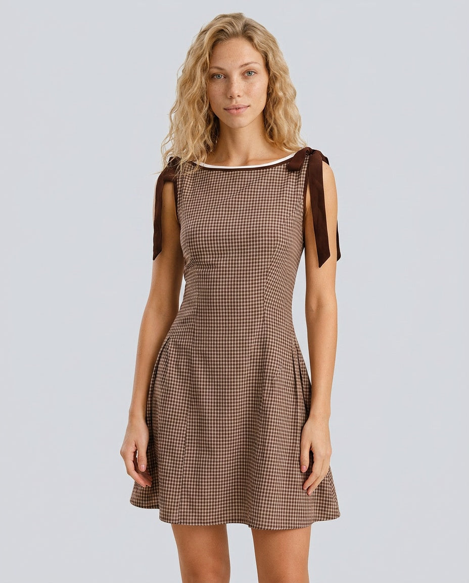 Women's sophisticated tie strap gingham mini dress. Perfect fit and flare style for summer brunch.