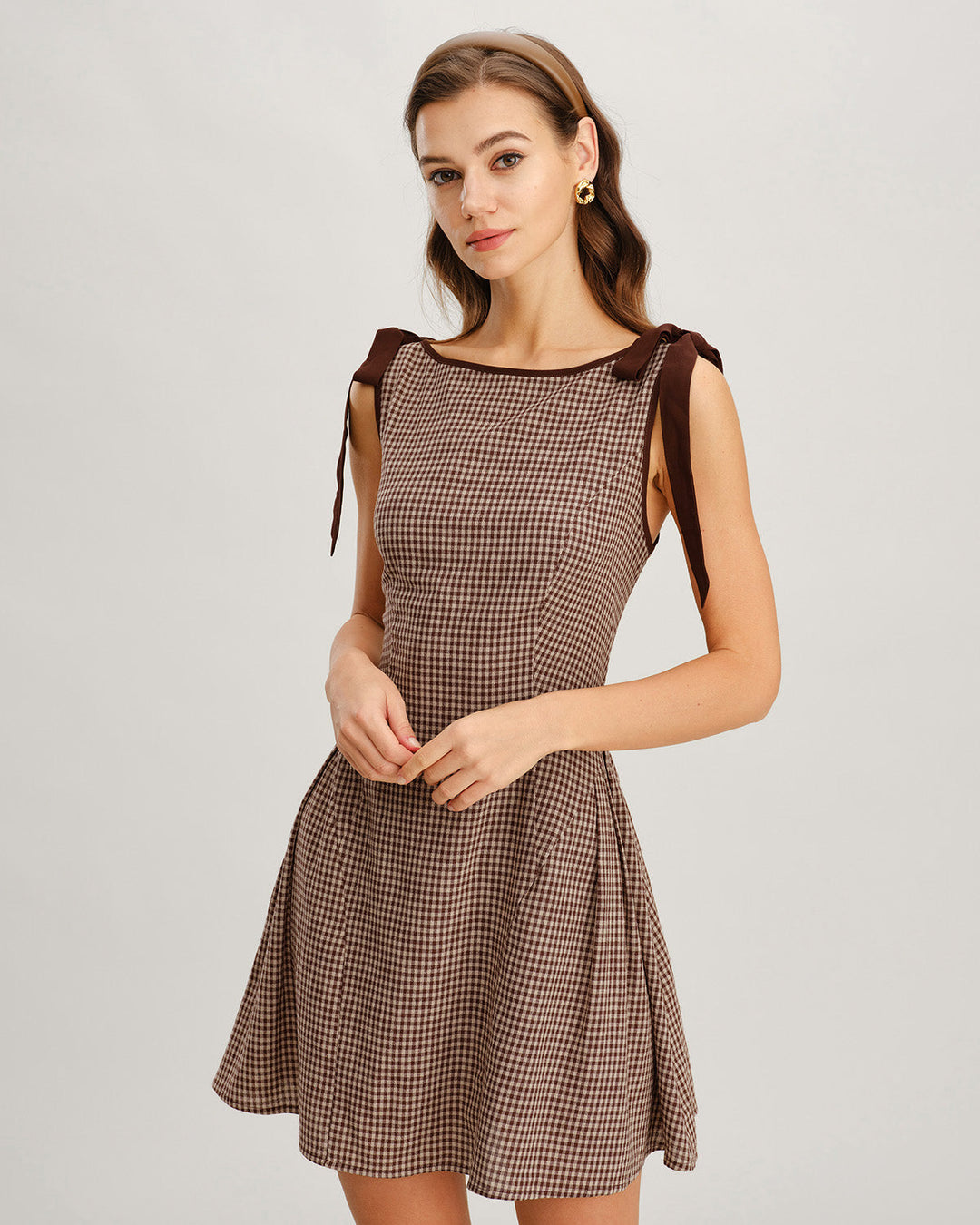 Stylish women's gingham mini dress featuring delicate tie straps. Versatile for brunch or casual elegance.