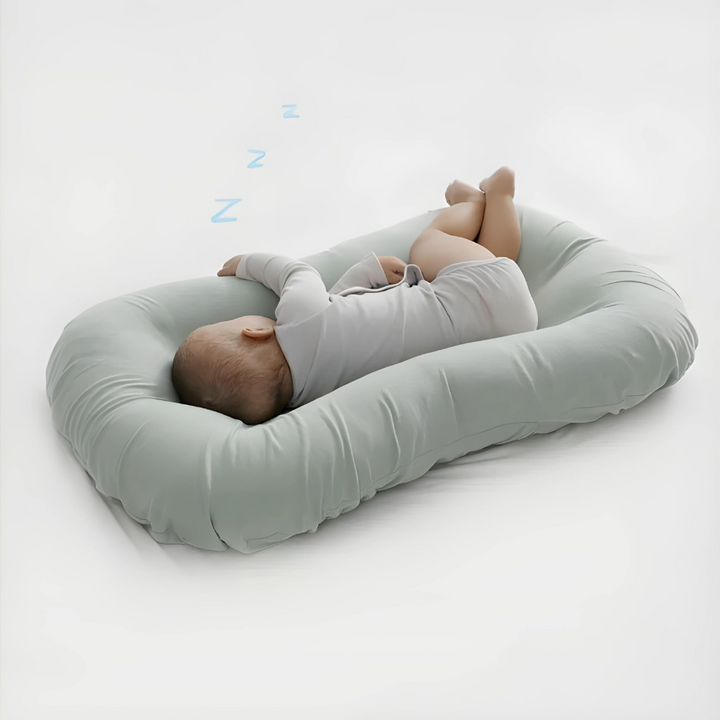 Green ergonomic baby pillow providing crucial head support during sleep for newborns.