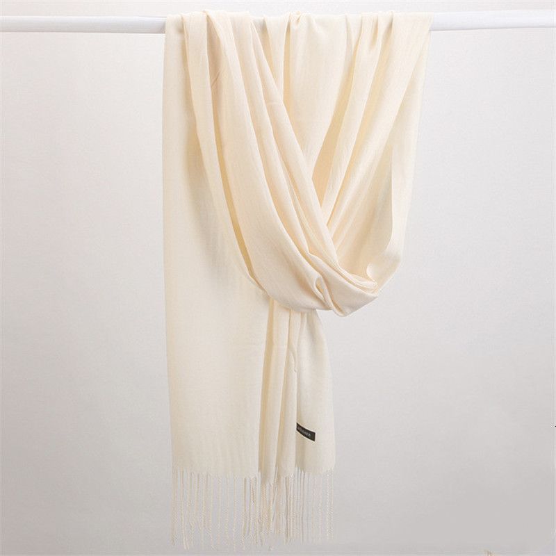 Woman wearing a luxurious cashmere scarf, elegantly draped for stylish winter fashion.