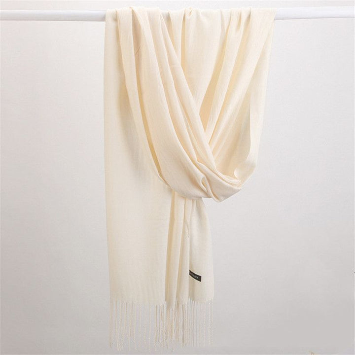 Woman wearing a luxurious cashmere scarf, elegantly draped for stylish winter fashion.