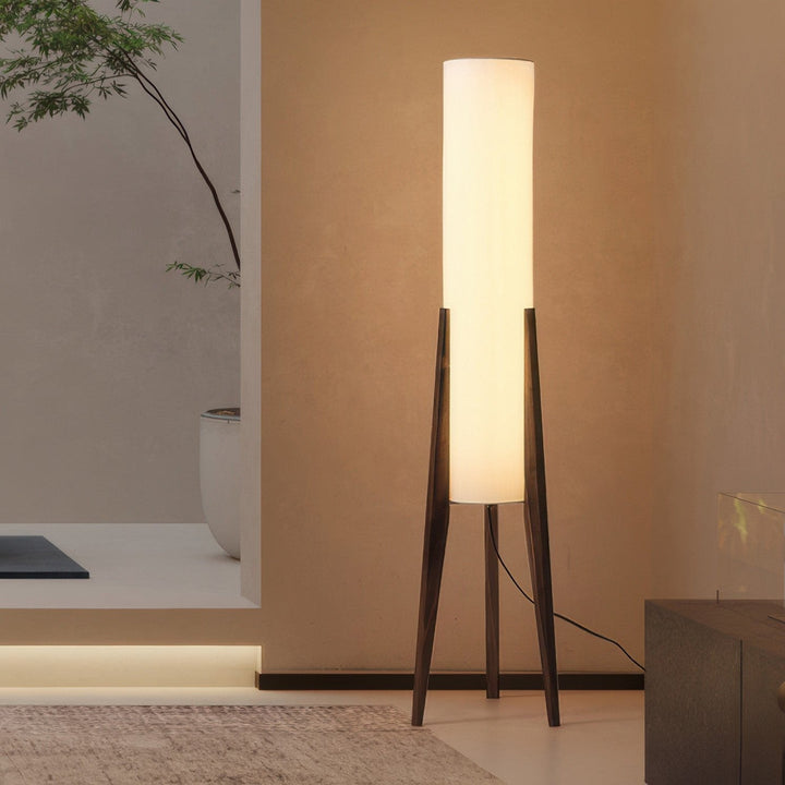 Modern wood floor lamp with fabric shade, providing ambient light for a cozy living room or bedroom setting.