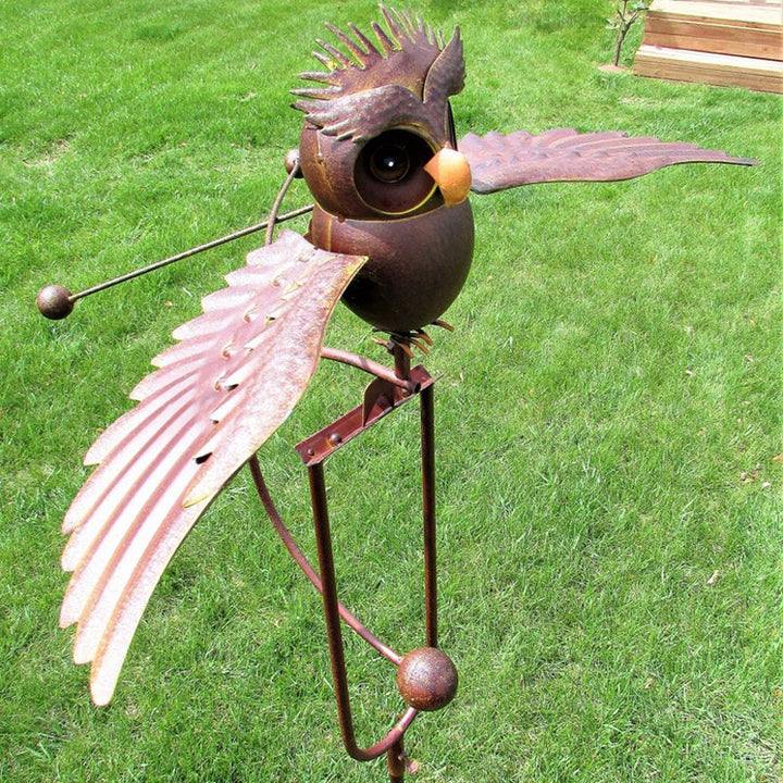 Wind-powered kinetic eagle garden statue. Detailed metal outdoor art decor, adding movement to your patio.
