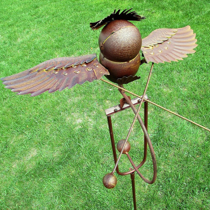 Captivating kinetic bird garden statue. Wind-powered metal art decor enhancing outdoor and patio environments.