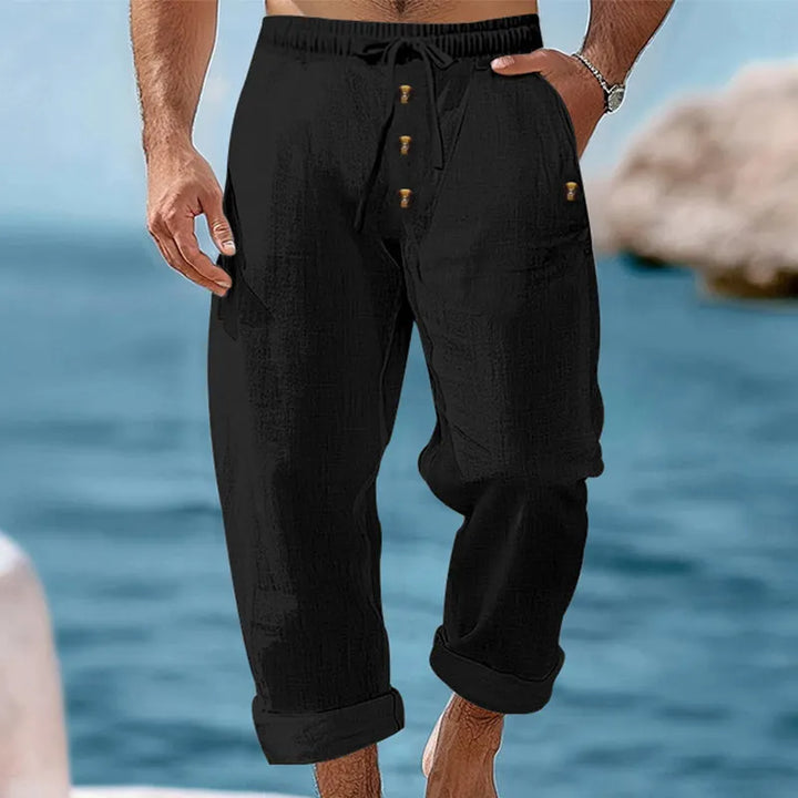 Men's relaxed fit linen cargo pants in a neutral color, styled for a casual summer day look.