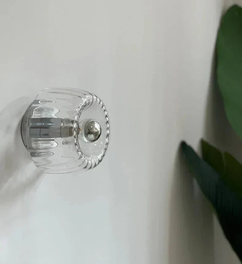Contemporary Bauhaus wall sconce, metal frame & glass shade. Modern interior lighting for living spaces.