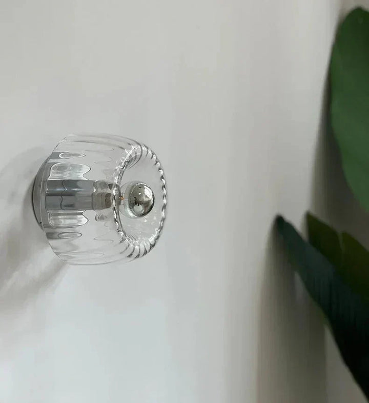 Contemporary Bauhaus wall sconce, metal frame & glass shade. Modern interior lighting for living spaces.