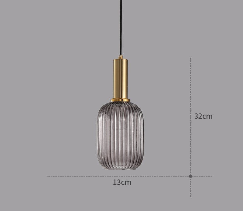 Decorative pendant light with a vintage colored glass shade, illuminated.