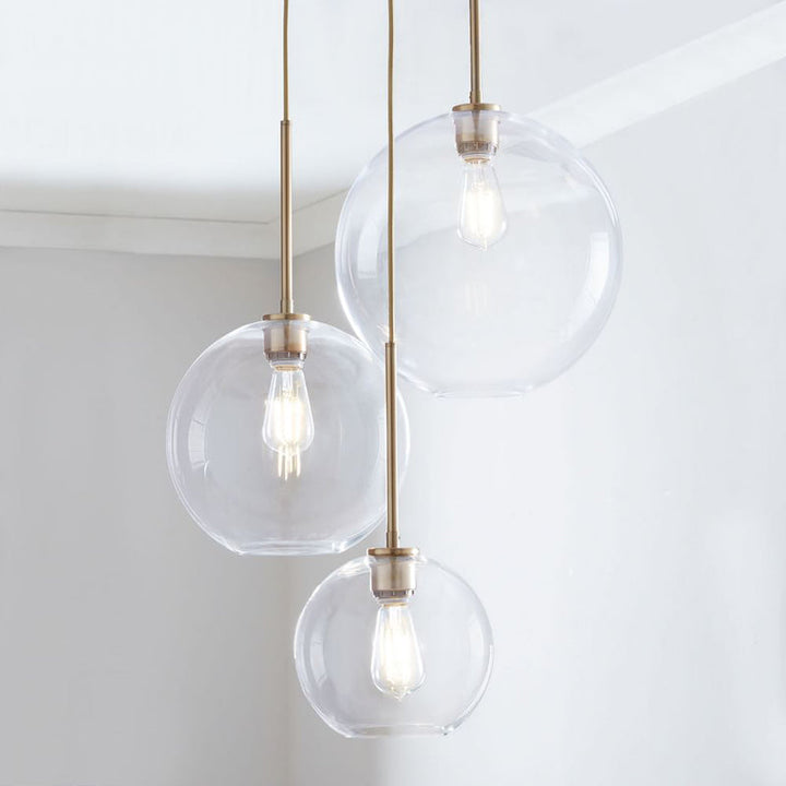 Modern glass ball pendant light with elegant brass finish for contemporary homes.