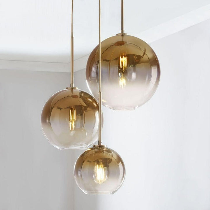 Gold gradient modern glass ball pendant light, a stylish ceiling fixture for living rooms.