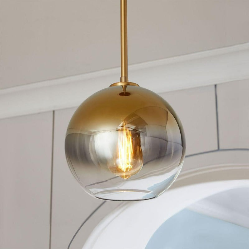 Modern gold gradient glass ball pendant light, a sophisticated ceiling fixture for upscale interiors.