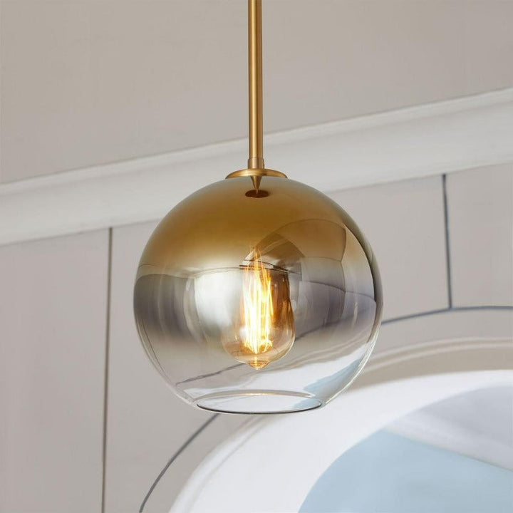 Modern gold gradient glass ball pendant light, a sophisticated ceiling fixture for upscale interiors.