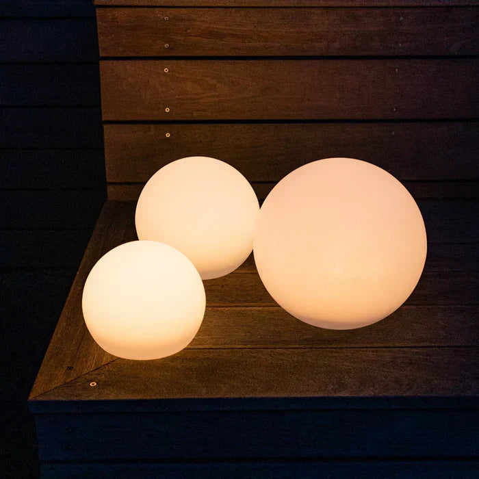 GlowSphere outdoor lighting illuminating a lush green lawn at dusk