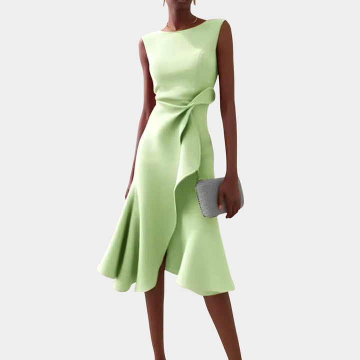 Woman walking gracefully in an elegant draped asymmetric midi dress, ideal for summer evening parties.