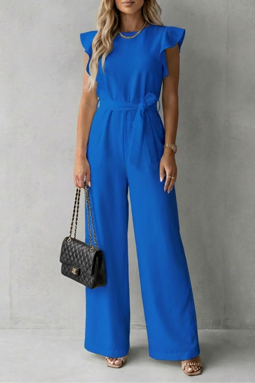 Modern women's wide-leg jumpsuit with stylish ruffle sleeves & a sophisticated belted waist. Contemporary fashion.