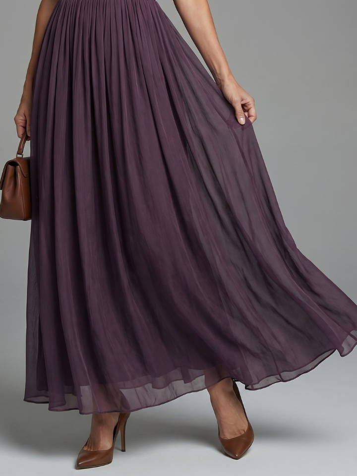 Feminine dark purple cocktail dress featuring an elegant lace neckline, sheer sleeves, and pleated waist.