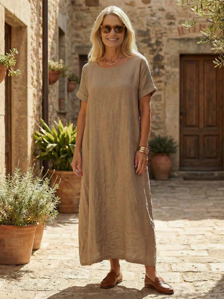 Relaxed fit women's casual midi dress. Features a round neck, cuffed sleeves, and comfortable crinkled texture.