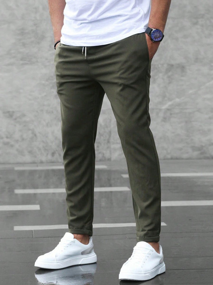 Grey men's slim-fit jogger chinos, perfect for a modern business casual look, featuring a comfortable drawstring.