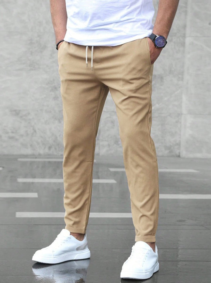 Detail shot of men's jogger chinos, highlighting the adjustable drawstring, slim-fit cut, and casual appeal.