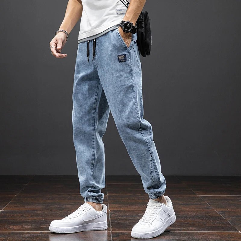 Men's blue stretch denim joggers; comfortable, tapered fit with elastic waist for casual modern style.